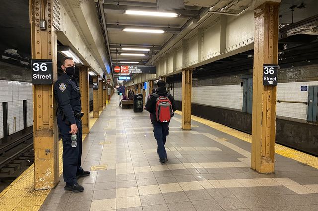 A police officer stands at the 36th Street station platform a day after a gunman opened fire on passengers